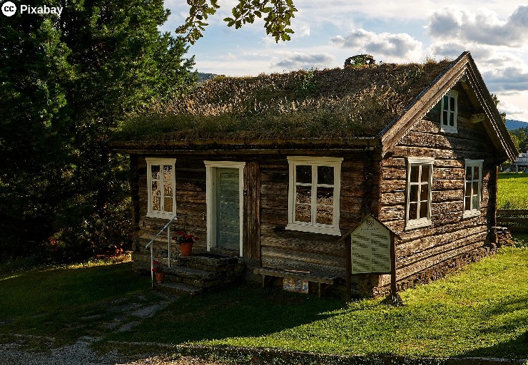 Ein Holzhaus mit einem grasbewachsenen Dach. Bild von Volker Gl&auml;tsch auf Pixabay.