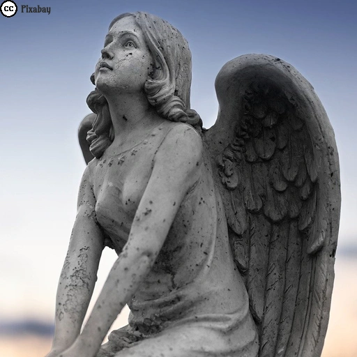 Das Foto einer Engelsstatue auf einem Friedhof im Dämmerlicht.
