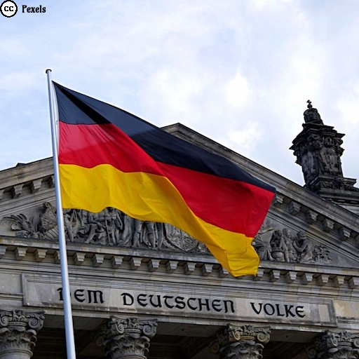 Vor dem Bundestag weht die Deutschlandfahne in schwarz-rot-gold. Foto von Ingo Joseph von Pexels.